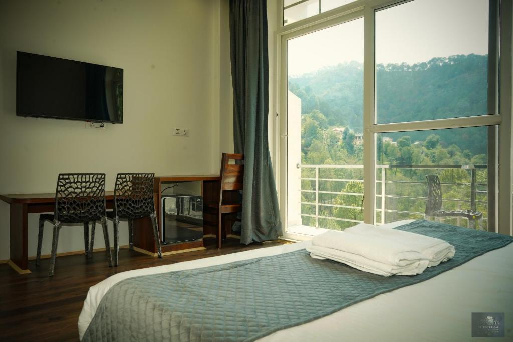 a bedroom with a bed and a large window at The Oaks - Scenic Couple Retreat in Kasauli with Private Balcony Views in Kasauli