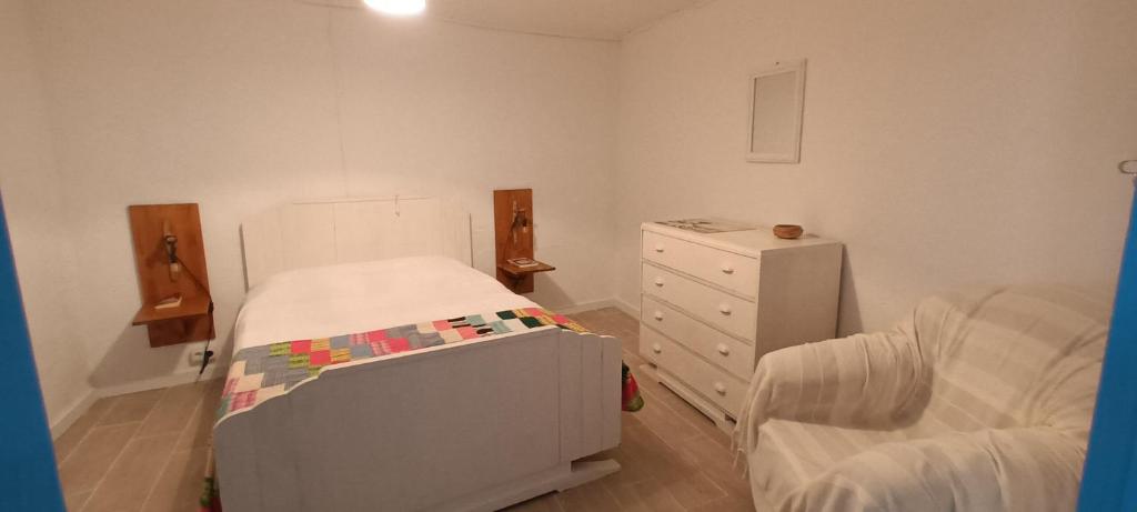 a small bedroom with a bed and a dresser at Casa Praia do Fogo in Ribeira Quente
