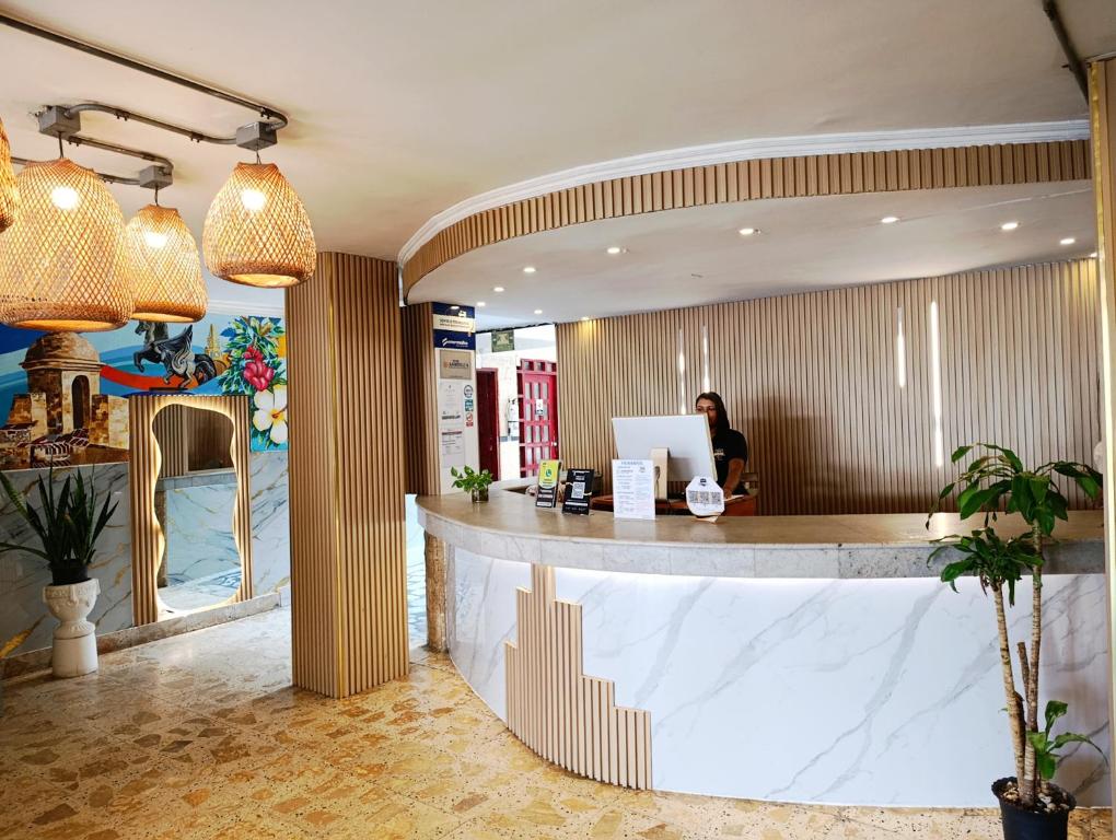 a woman sitting at a counter in a restaurant at Hotel Toledo FL in Cartagena de Indias