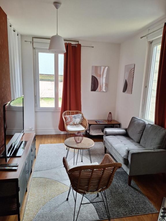 a living room with a couch and a tv at Les Arquebusiers in Chalons en Champagne