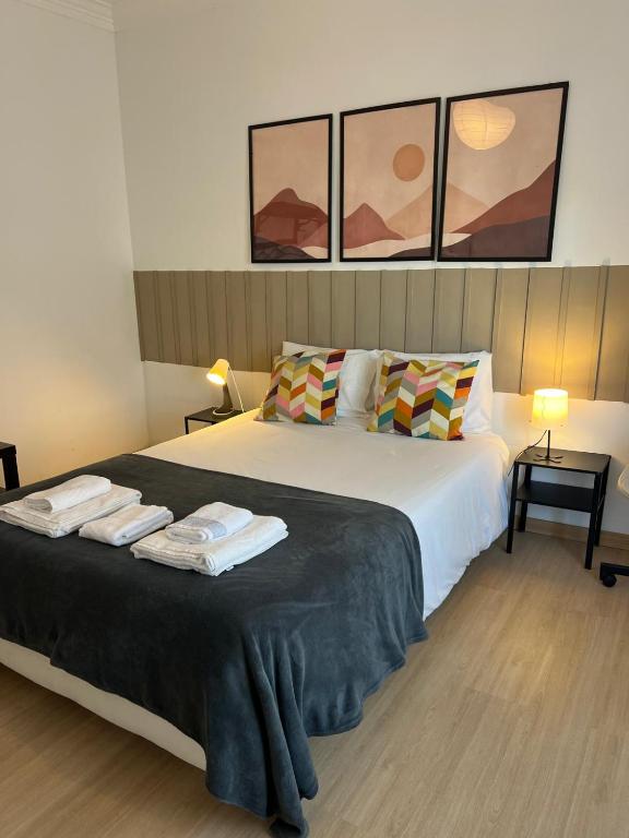 a bedroom with a large bed with towels on it at Alvalade II Airport Guest House in Lisbon