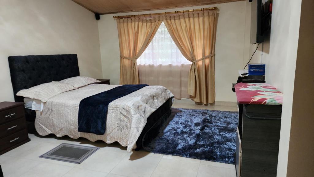 a bedroom with a bed and a window at Villa Tungurahua in Huamboya