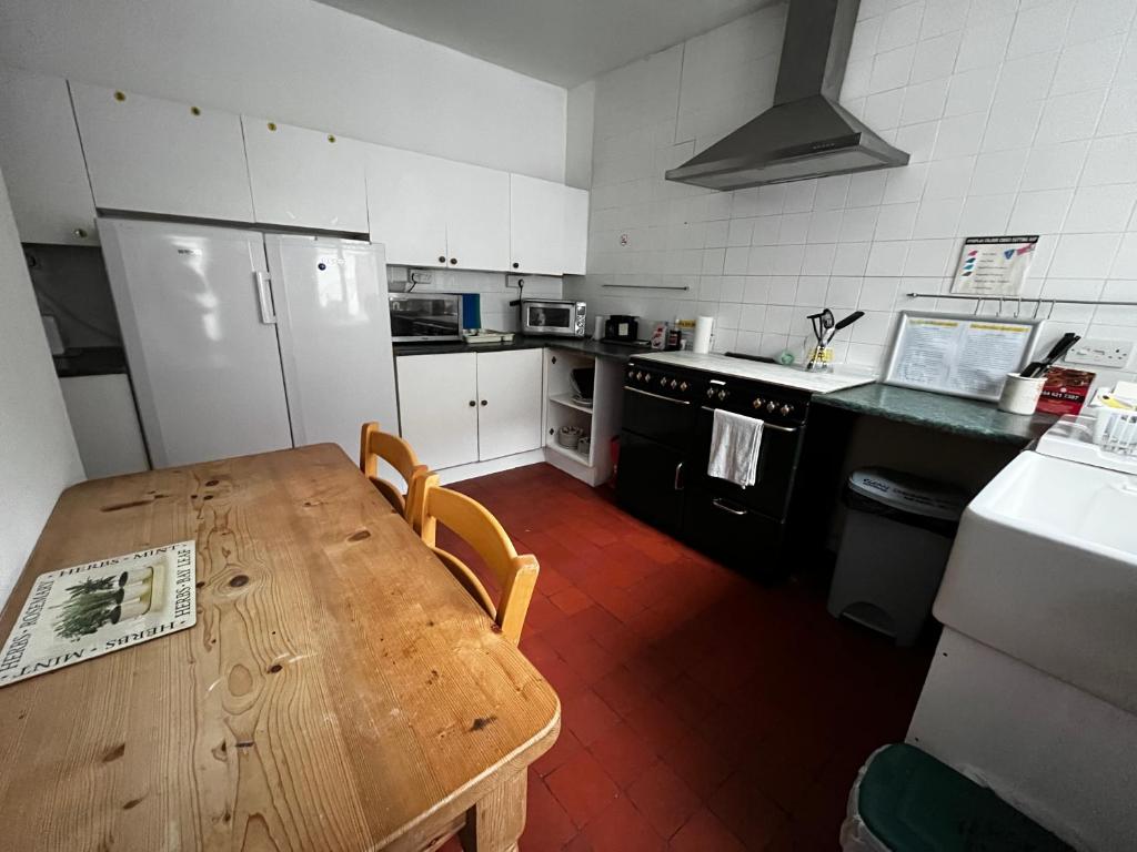 eine Küche mit einem Holztisch und einem Kühlschrank in der Unterkunft The Innbetween in Pembroke Dock