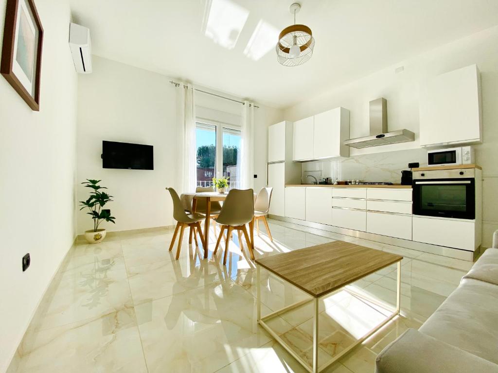 a white living room with a table and chairs at Corso 42 in Novara