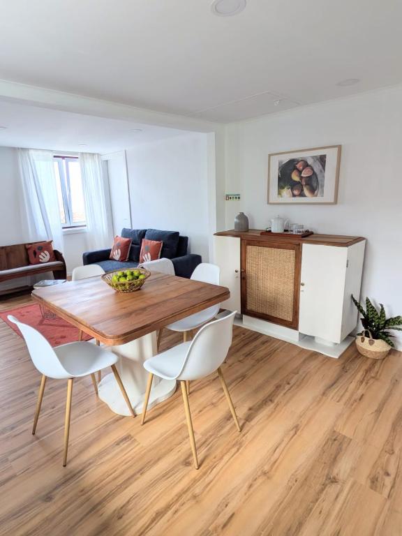 a living room with a wooden table and chairs at Casa da Avó Elvina in Angra do Heroísmo