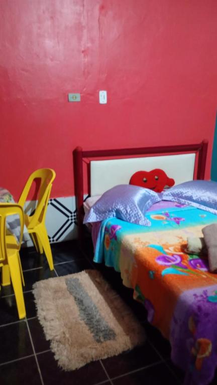 a bedroom with a bed and a red wall at Pousada Nosso cantinho in Belém