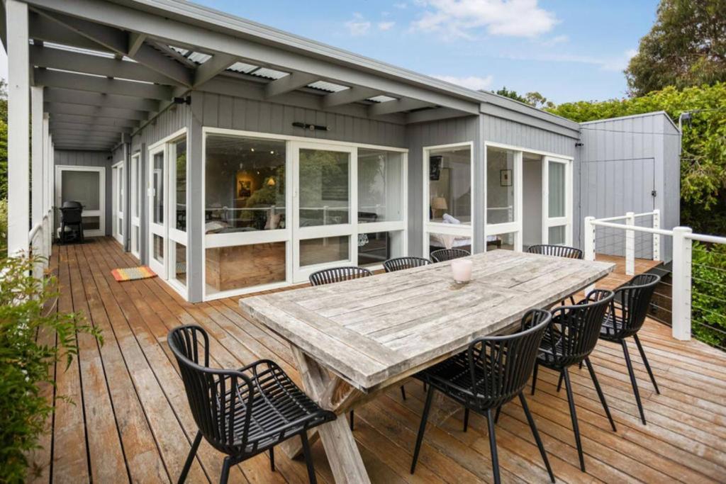 a wooden deck with a table and chairs at The Deck House in Lorne