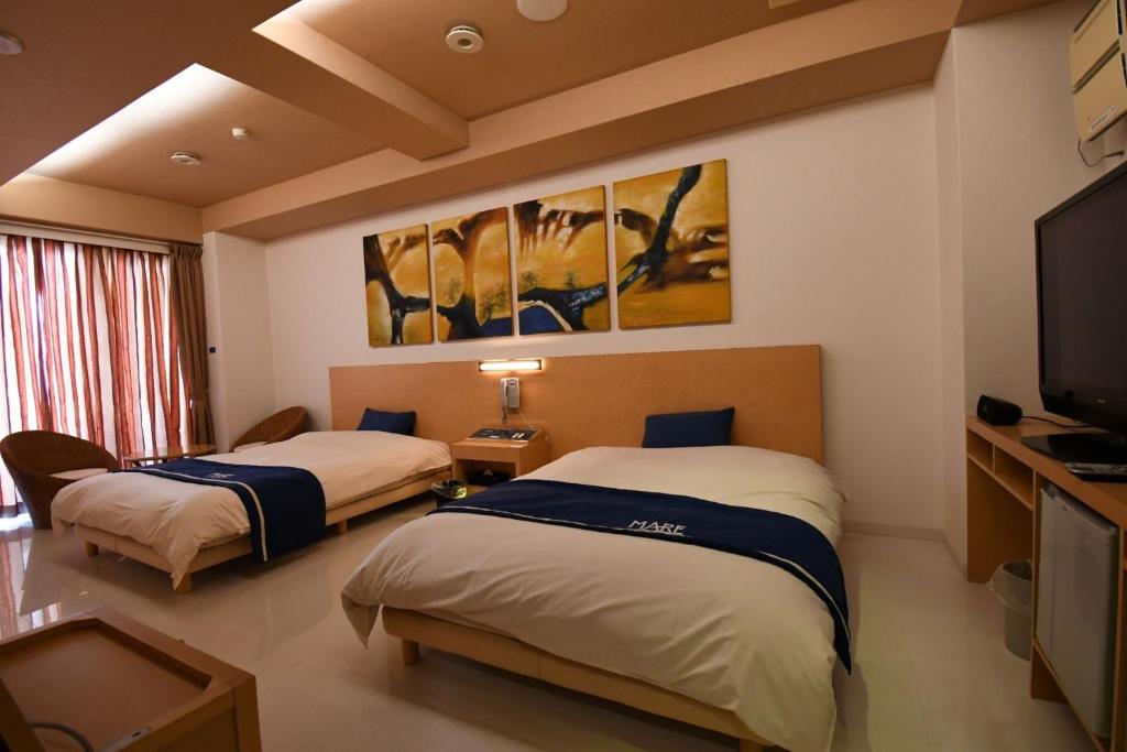 two beds in a hotel room with a tv at Hotel Mare - Vacation STAY 58144v in Kure