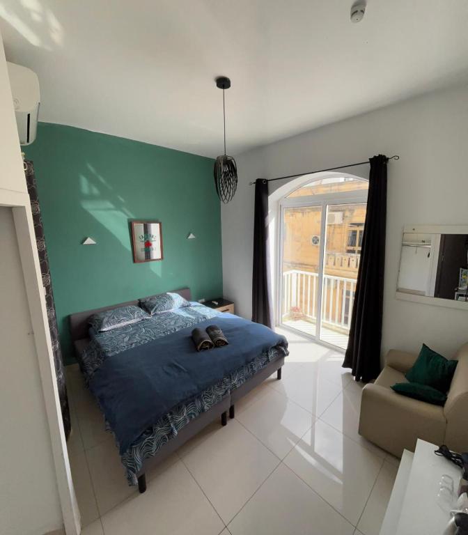 a bedroom with a bed and a green wall at Next to beach Sliema Stay, Cozy, Air-Conditioned, Self Check-In in Il-Gżira