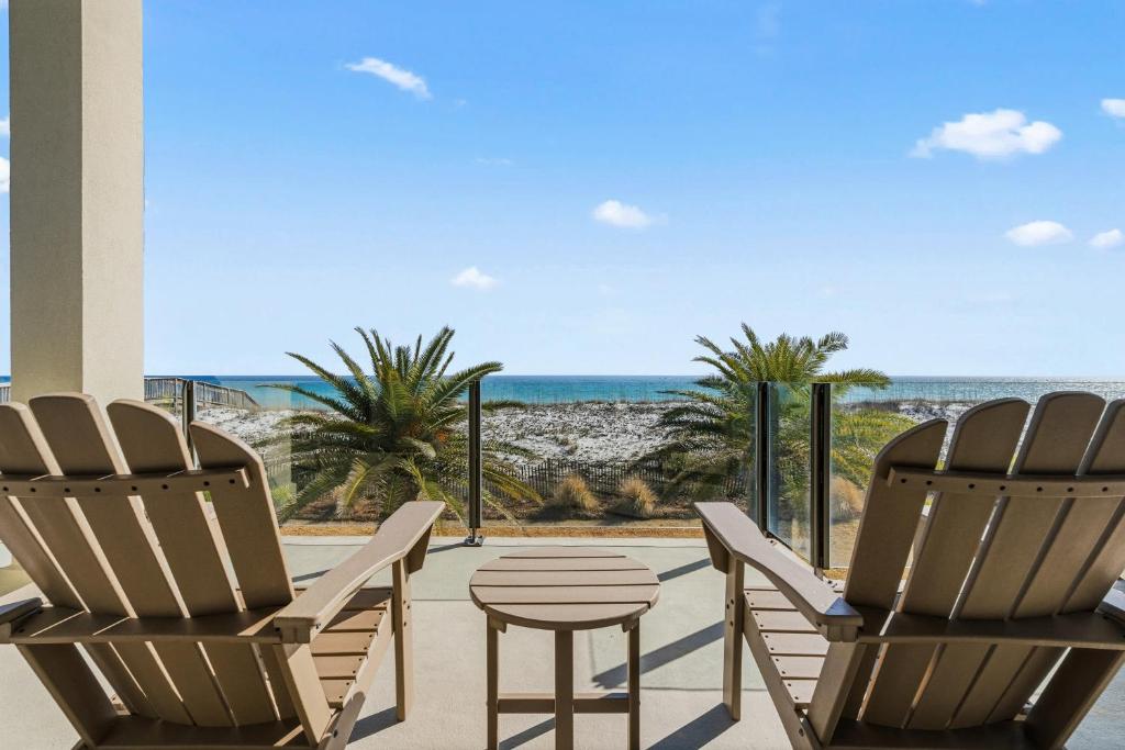 two chairs and a table on a patio with the beach at Honeysuckle Blue in Pensacola Beach