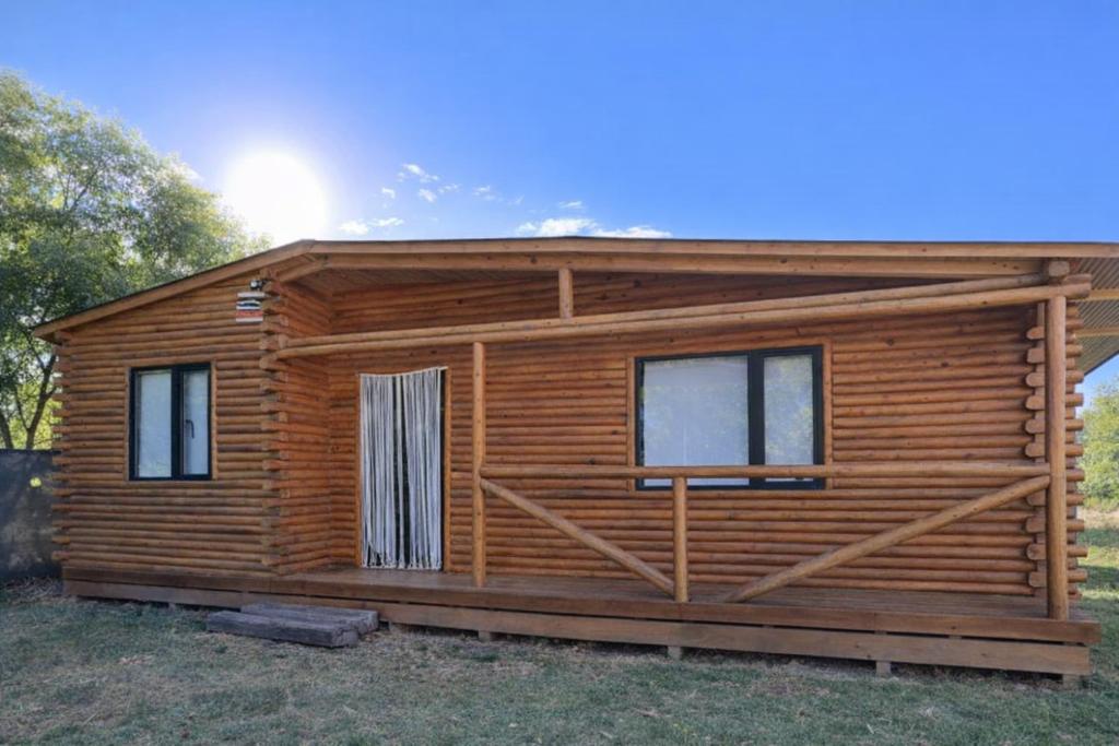 a log cabin with windows on a field at Cabaña Doña Loly in Olavarría