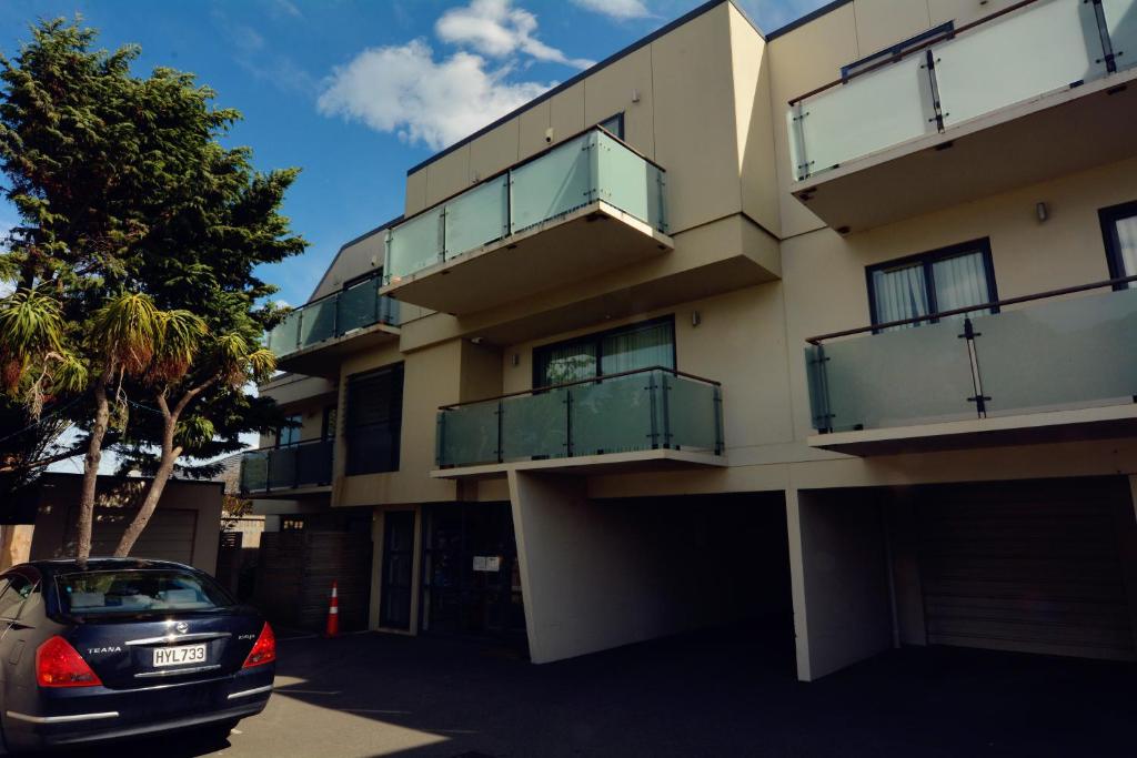 un coche aparcado delante de un edificio en BeachLife Apartments, en Christchurch