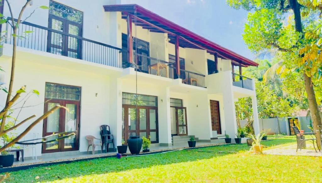 a large white house with a yard at Villa 188 Yala in Tissamaharama