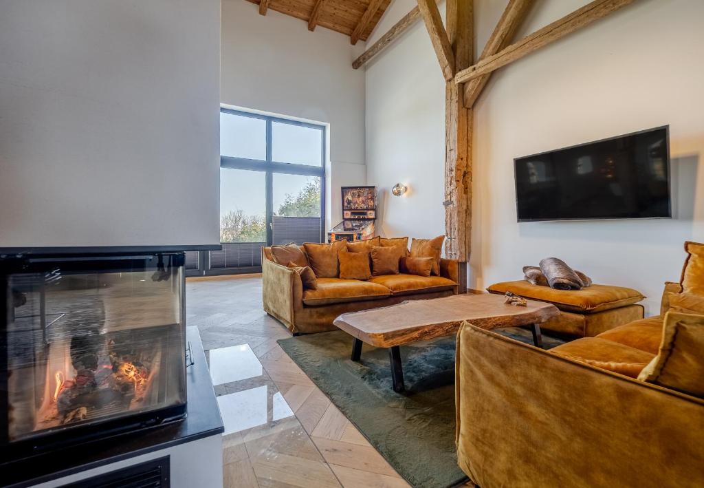 a living room with couches and a fireplace at Scheune 1746 in Tating