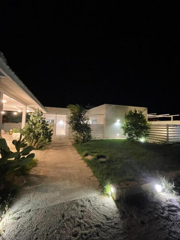 a house with lights in the yard at night at SeA Beach Home in Torre Lapillo