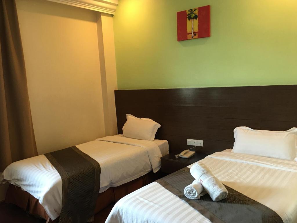 Postel nebo postele na pokoji v ubytování Lintas Plaza Hotel