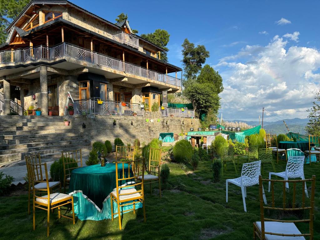 a group of chairs and tables in front of a building at Pine Grey Castle in Almora
