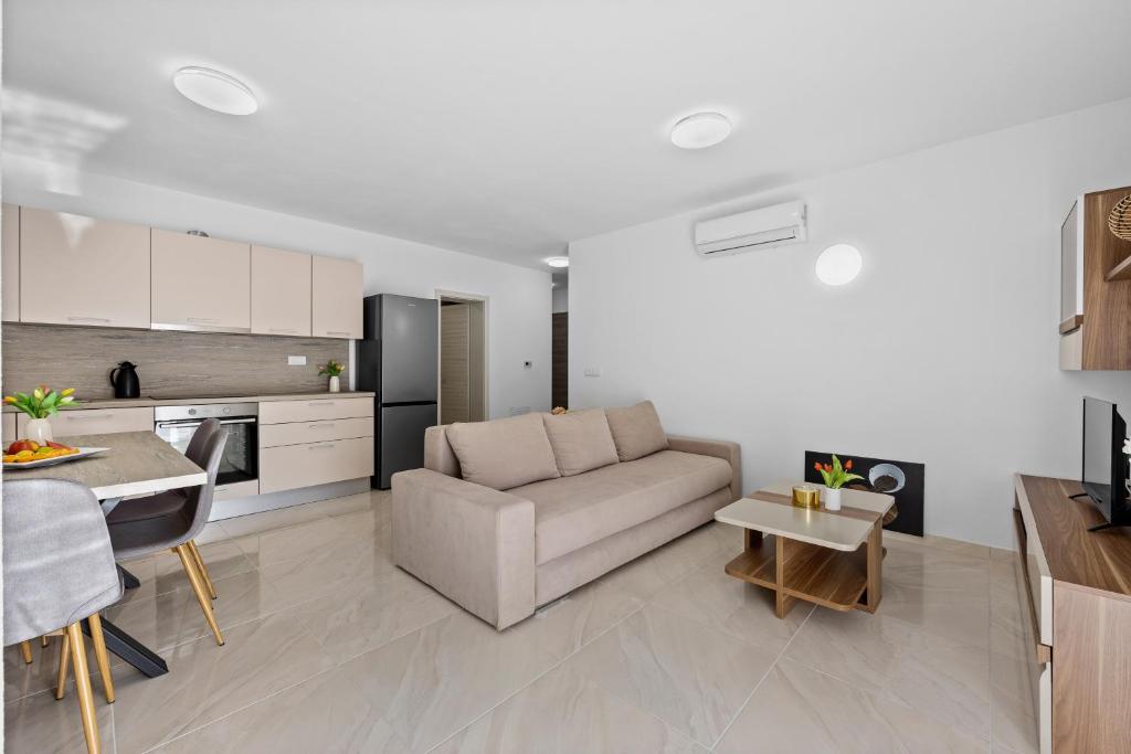 a living room with a couch and a kitchen at Apartment Lola in Peroj