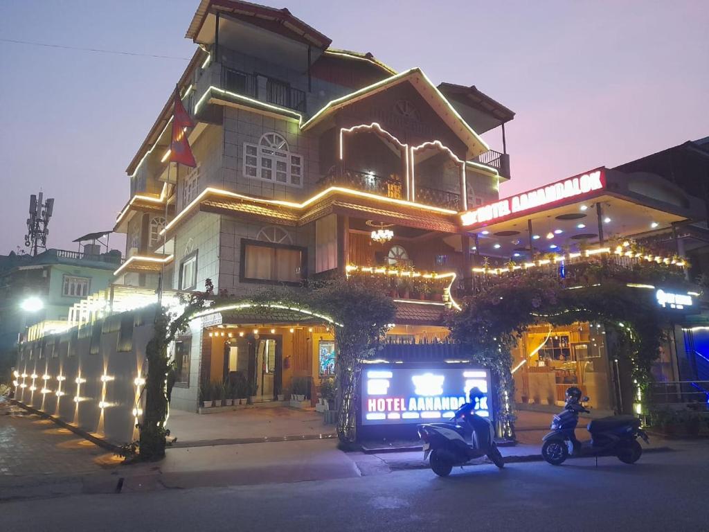 two motorcycles parked in front of a building with christmas lights at Hotel Aanandalok in Pānigata