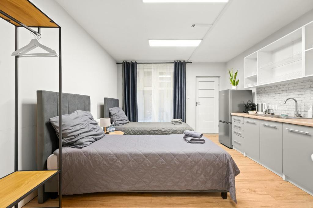 a bedroom with a bed and a kitchen at Central Platinum Apartments 5 Studio z aneksem kuchennym i tarasem in Rybnik