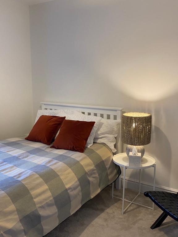 a bedroom with a bed and a table with a lamp at Cosy 1 bedroom in Abingdon