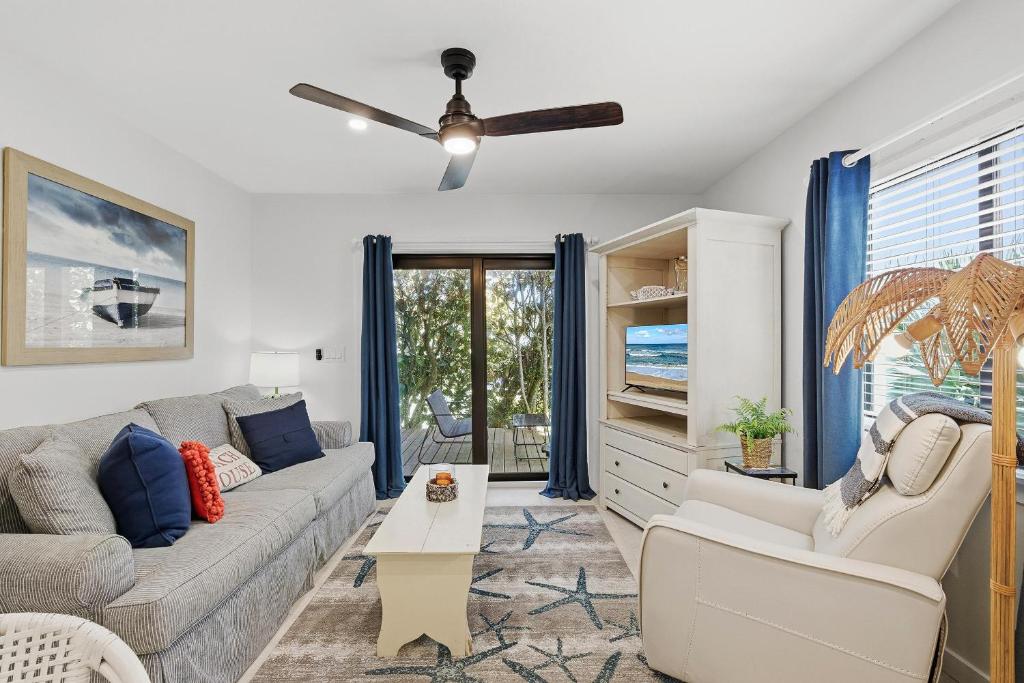a living room with a couch and a ceiling fan at Sea Dunes Nautilus B8 in New Smyrna Beach