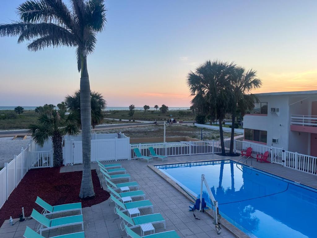 a swimming pool with stairs and a palm tree at Arvilla Resort in St. Pete Beach