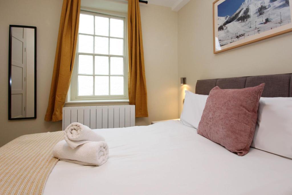 a bedroom with a bed with a towel on it at St John's Hill Apartments in Shrewsbury