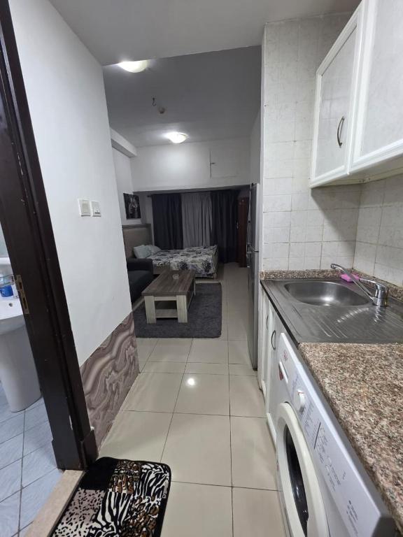 a kitchen with a sink and a washing machine at Apartment condo in Ajman in Ajman 