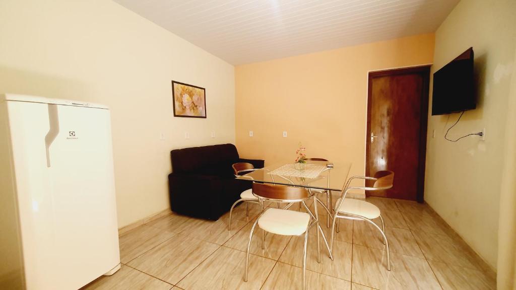 a living room with a table and chairs and a couch at Casa Miríades in Hortolândia