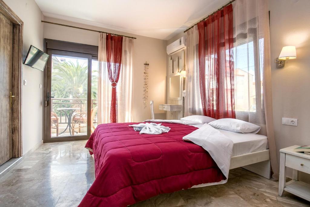 a bedroom with a bed with a red blanket at Agali Villa in Limenaria