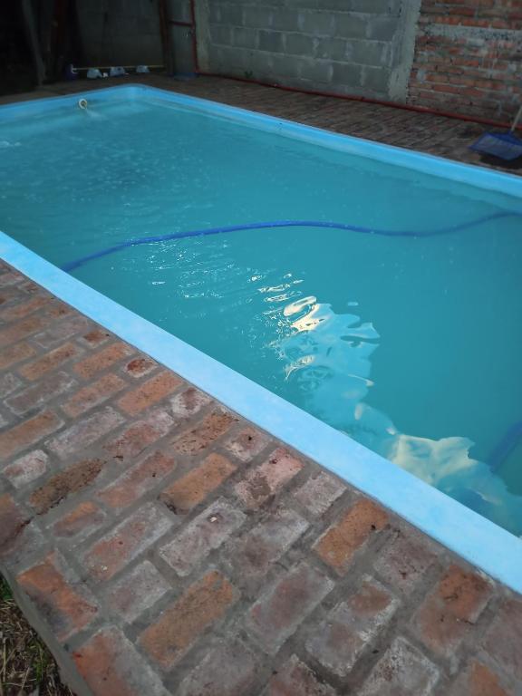a swimming pool with blue water in a brick yard at Los eucaliptos in Andino