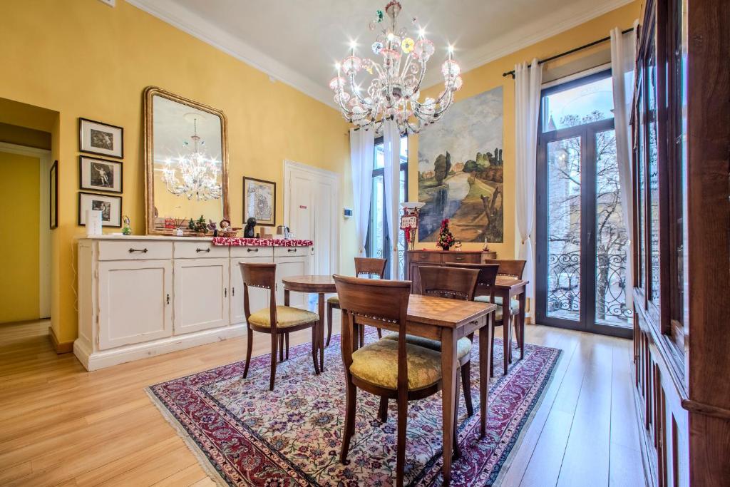 a dining room with a table and chairs and a chandelier at Casa Esvael - Historic Rooms in Verona City Center in Verona