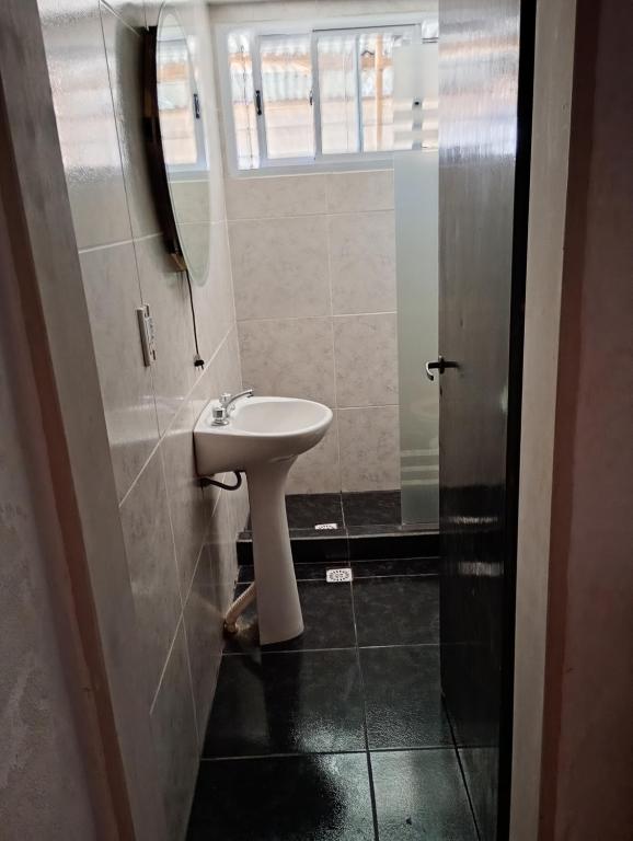 a bathroom with a white sink and a window at Valdez Resi in Santa Rosa