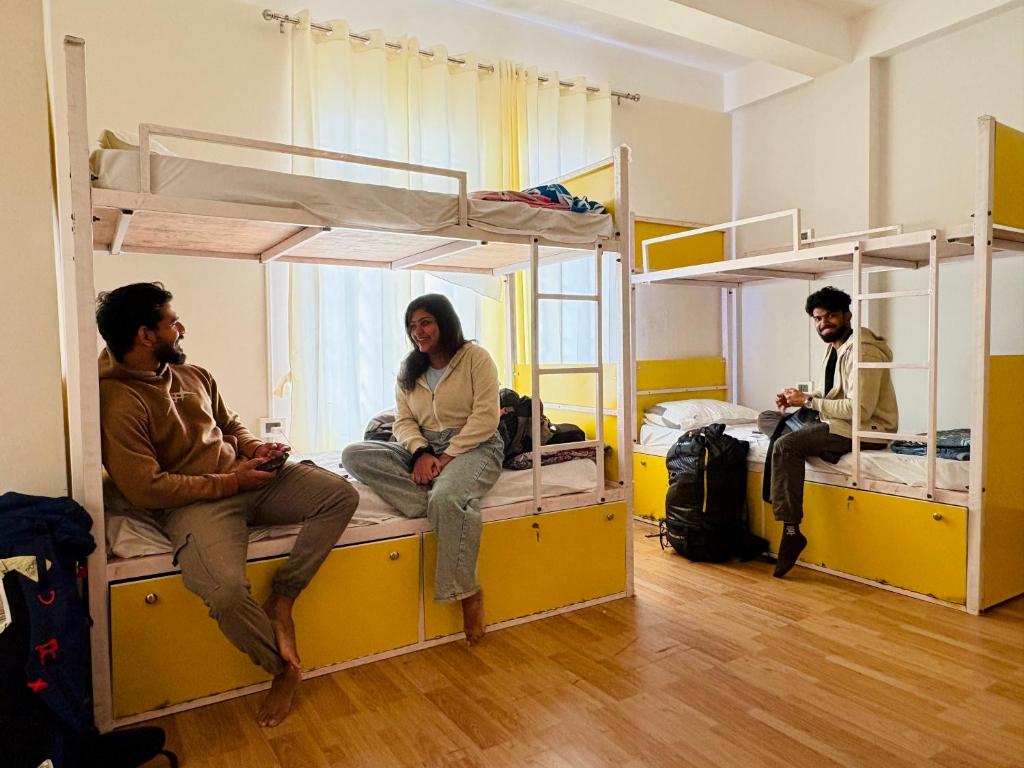 a group of people sitting on bunk beds in a room at Yaro Backpackers Hostel in Guwahati