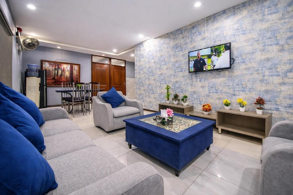 a living room with couches and a tv on a brick wall at Private 2BD Apartment Opposite Dha Phase 8 in Lahore