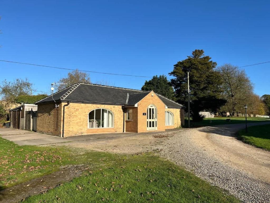 a house on a dirt road next to a driveway at Walworth Castle Cottage in Darlington