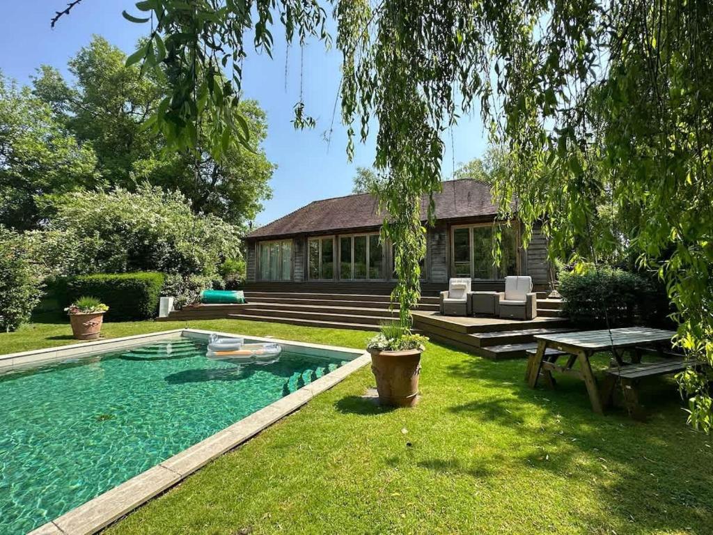 a backyard with a swimming pool and a house at Pool House at Mill Cottage in Goring