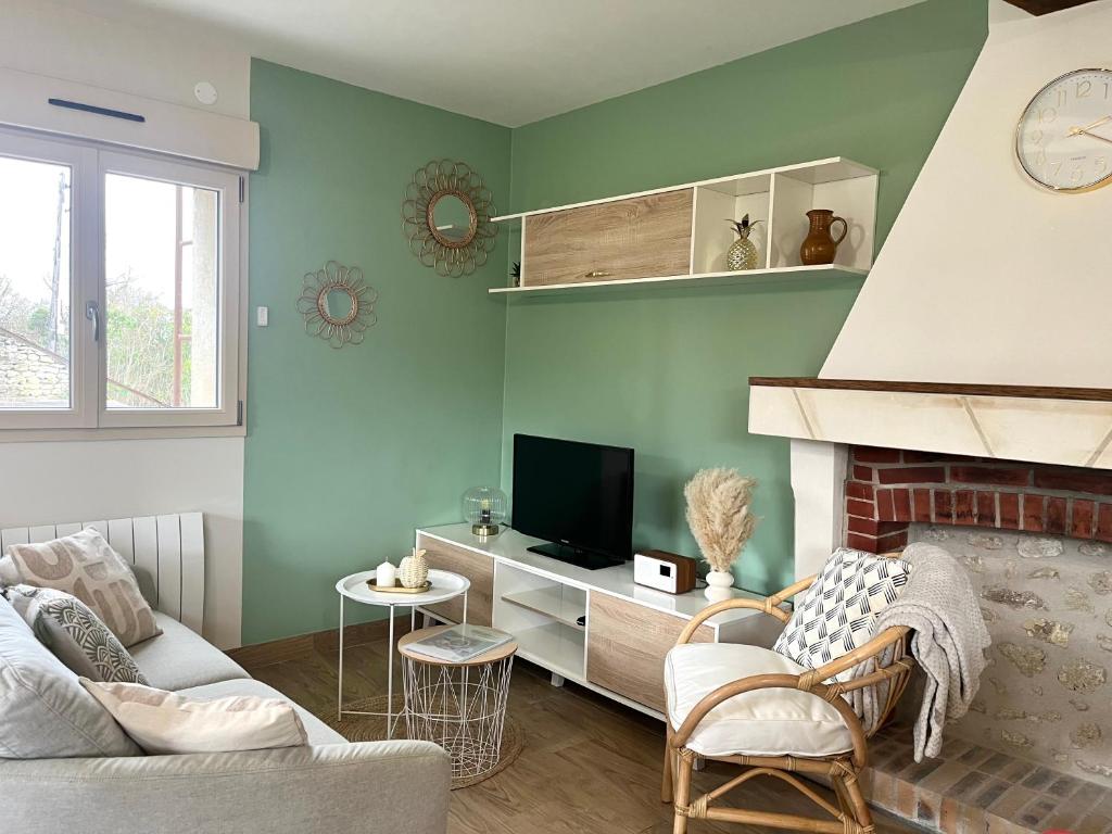 a living room with a fireplace and a tv at La Maison Agoméa in Saint-Georges-sur-Cher