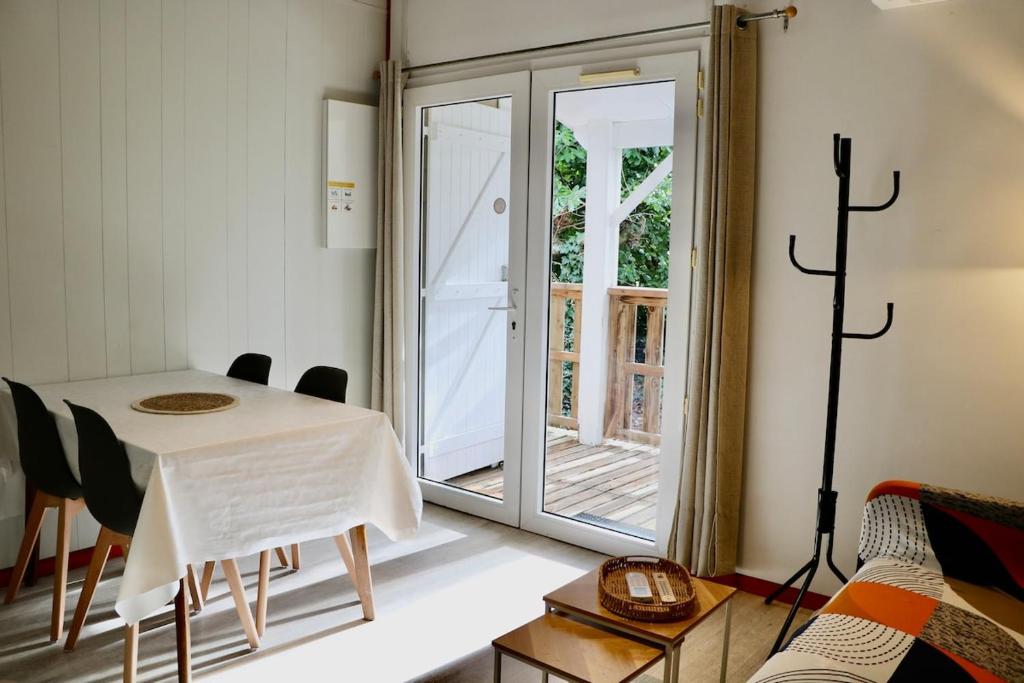 a dining room with a table and a glass door at Le Havre de Paix Chalet in Rivières