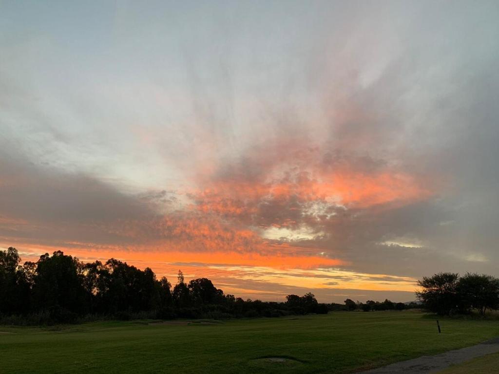 a sunset over a golf course with a green field at Sunset View Vaal De Grace in Grooteiland