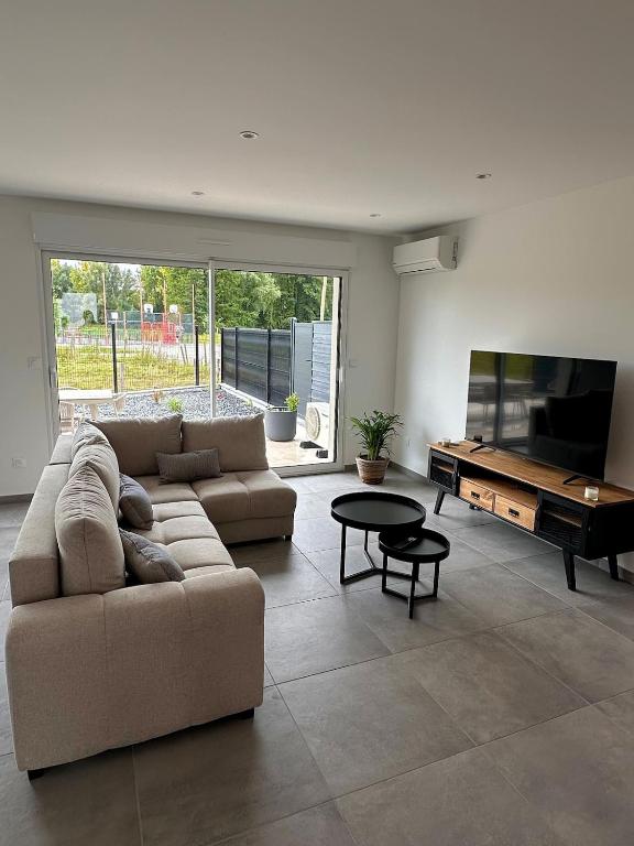 a living room with a couch and a table at La maison des étangs in Rebecques