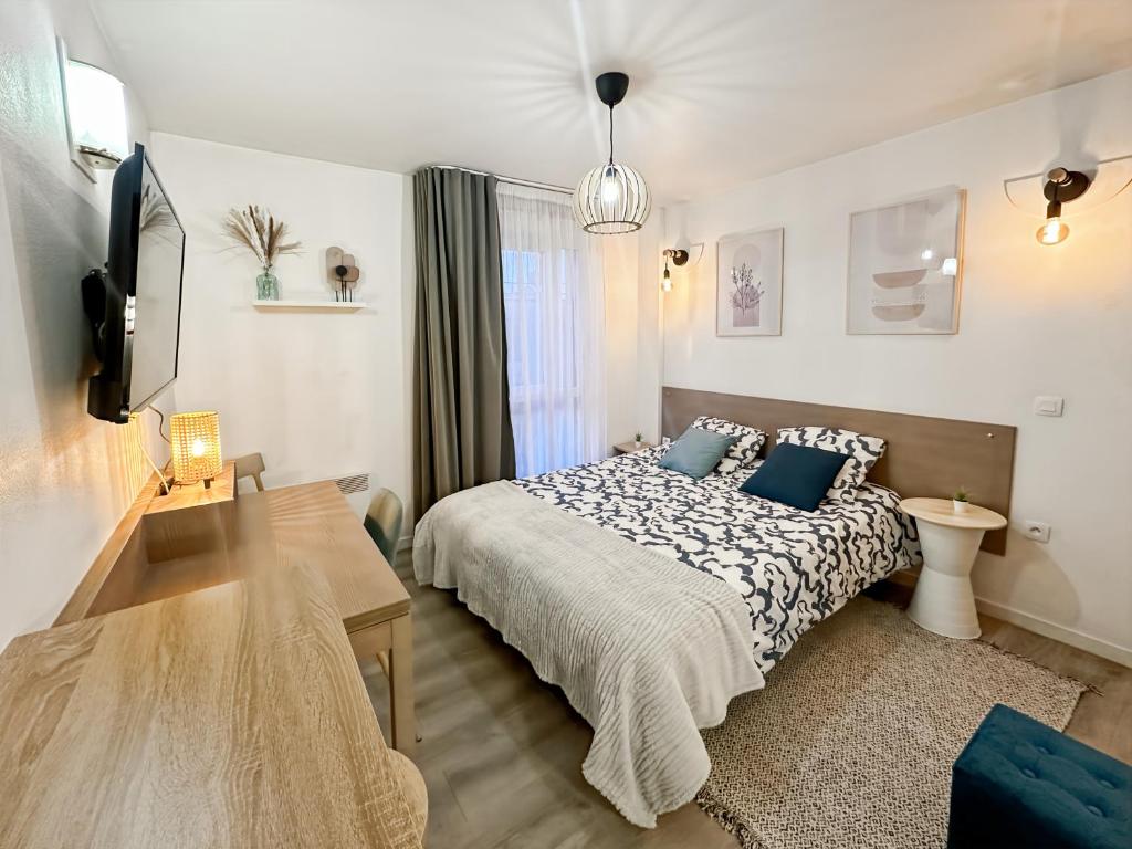 a bedroom with a bed with blue pillows on it at Le Cosy Saint-Cyr in Saint-Cyr-lʼÉcole