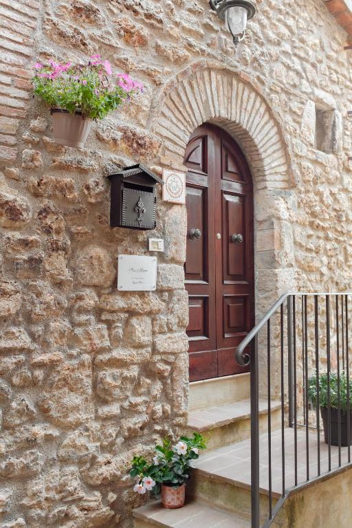 a stone building with a door and a clock on it at A casa di Mimma in Acquasparta