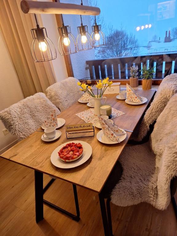 a wooden table with plates of food on it at Ferienwohnung Allgäuerle 1605 Ski in Ski out an der Skipiste mit Hallenbad Sauna und Tiefgarage in Missen-Wilhams