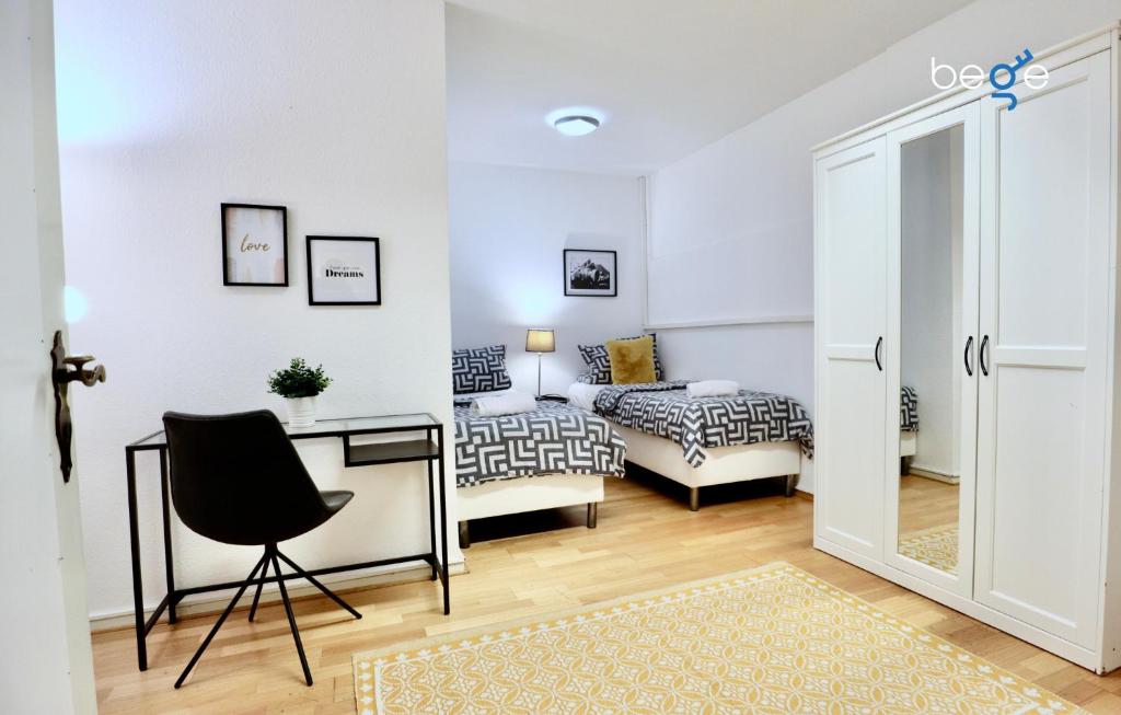a bedroom with a desk and a bed and a room at BEGE APARTMENTS CitySleep in Aachen