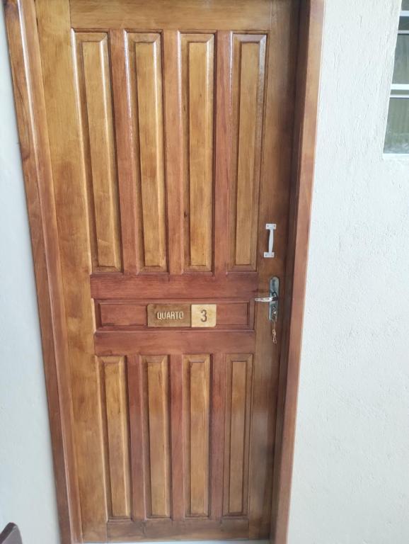 a wooden door with a sign on it at Quarto pra OITO 8 Pessoas in Ouro Preto