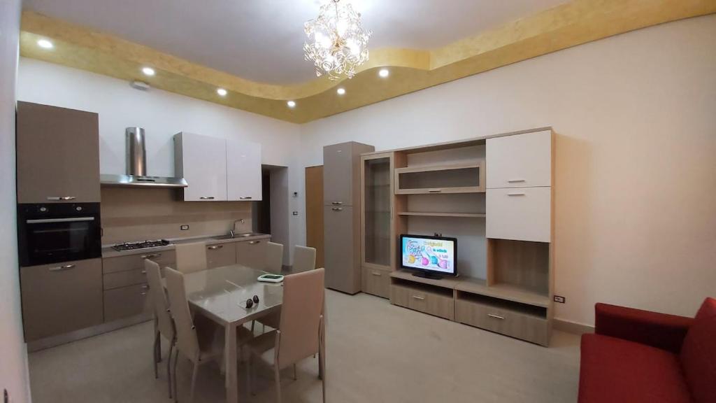 a kitchen with a table and a tv in it at Alisia Apartment in Rossano Stazione