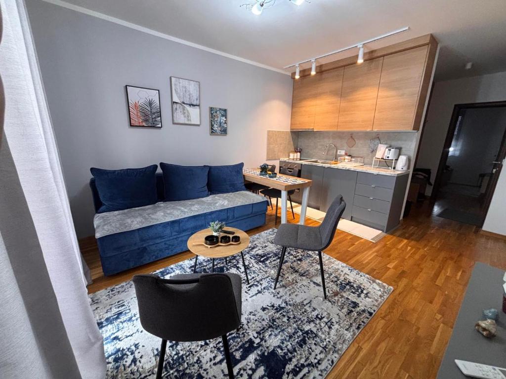 a living room with a blue couch and a table at Apartman Mireli in Zlatibor
