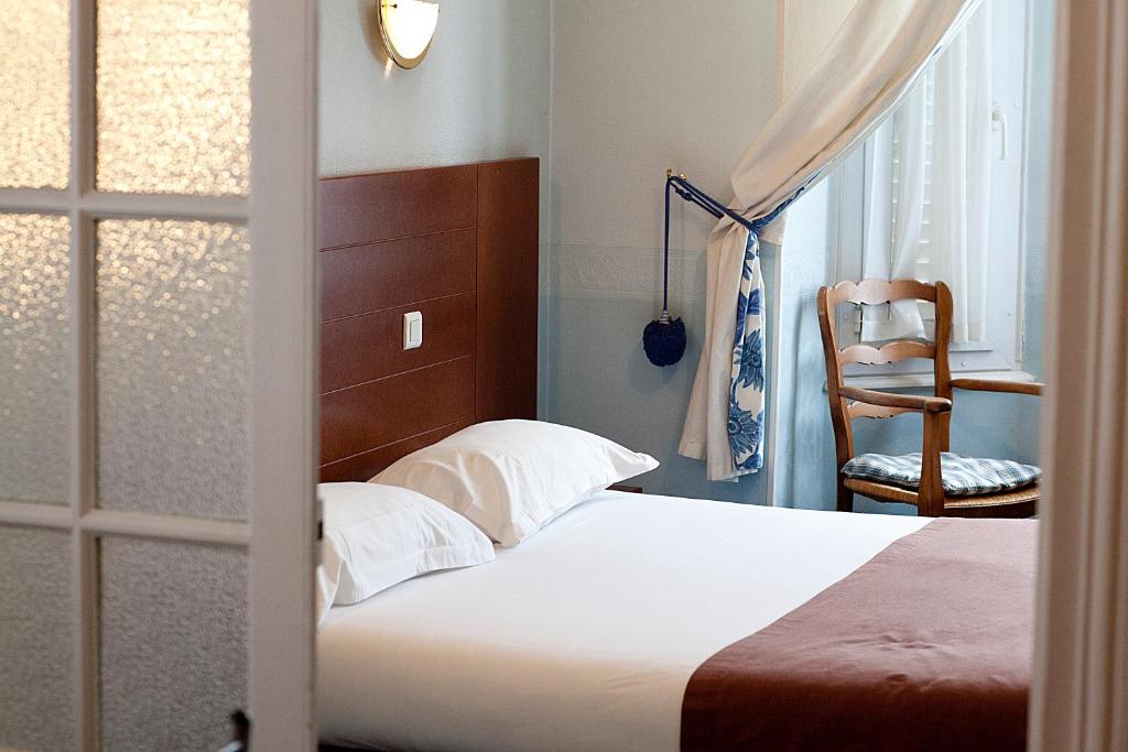 - une chambre avec un lit, une chaise et une fenêtre dans l'établissement Le Chatel, à Royat